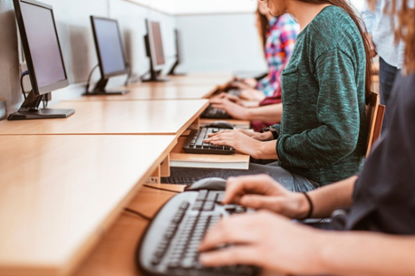 A group of aspiring employees typing on a computer for skills-based hiring.