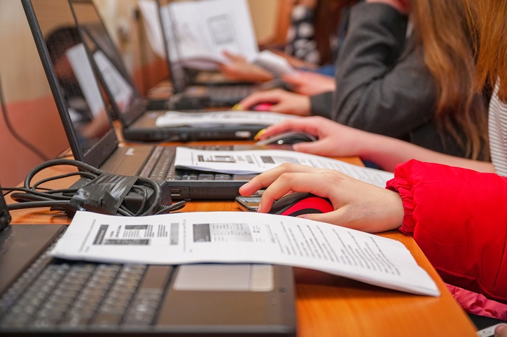 A group of workers encoded something on the computer for their employee skills assessment.